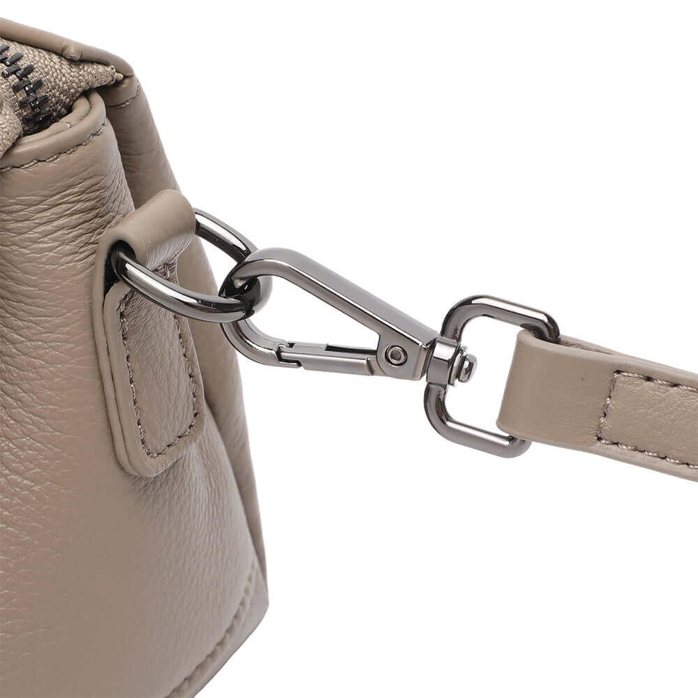 Metal hardware close-up of women’s taupe genuine leather crossbody bag