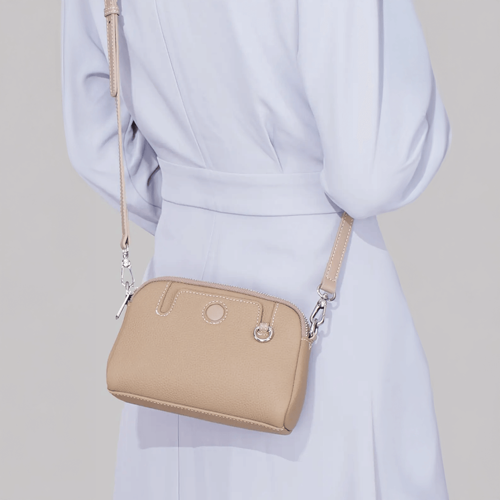 Mini leather crossbody bag worn on the back by model for daily styling.