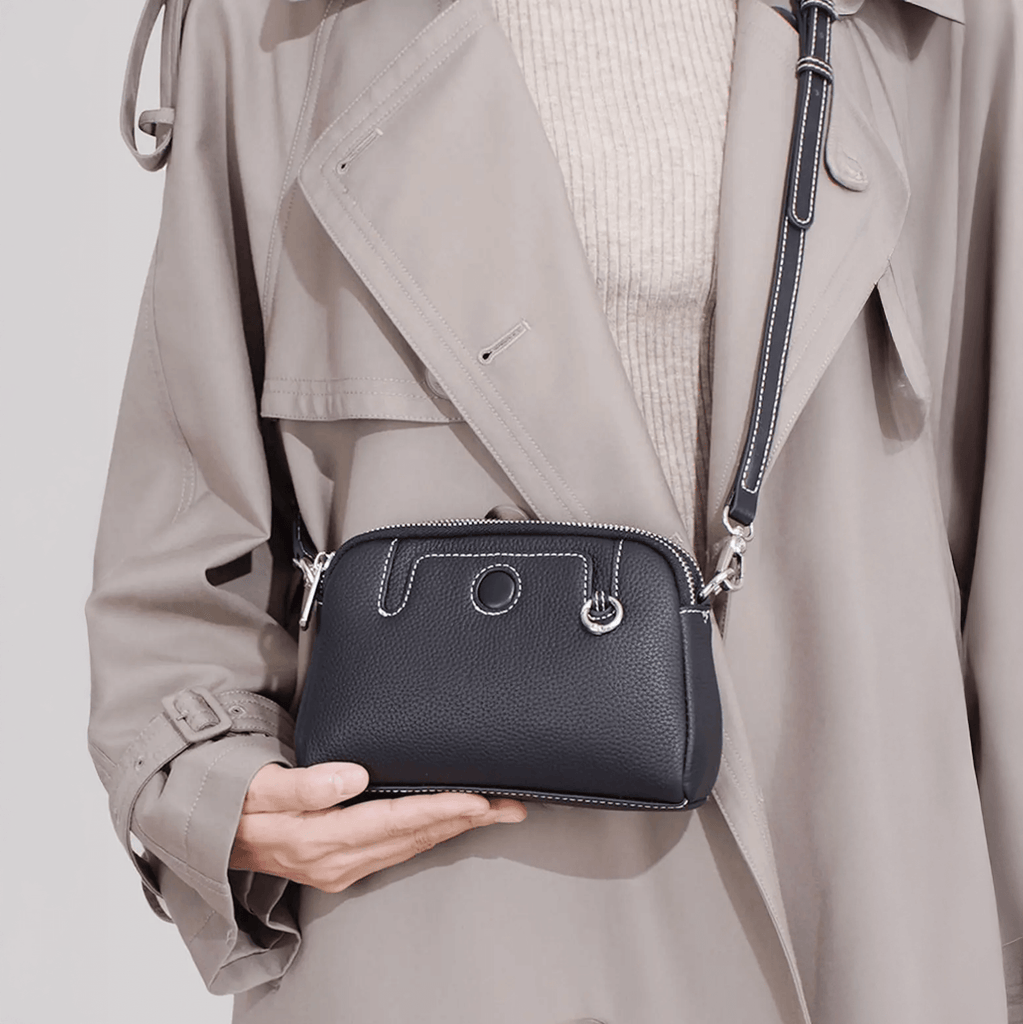 Model holding mini leather crossbody bag for casual everyday outfit.