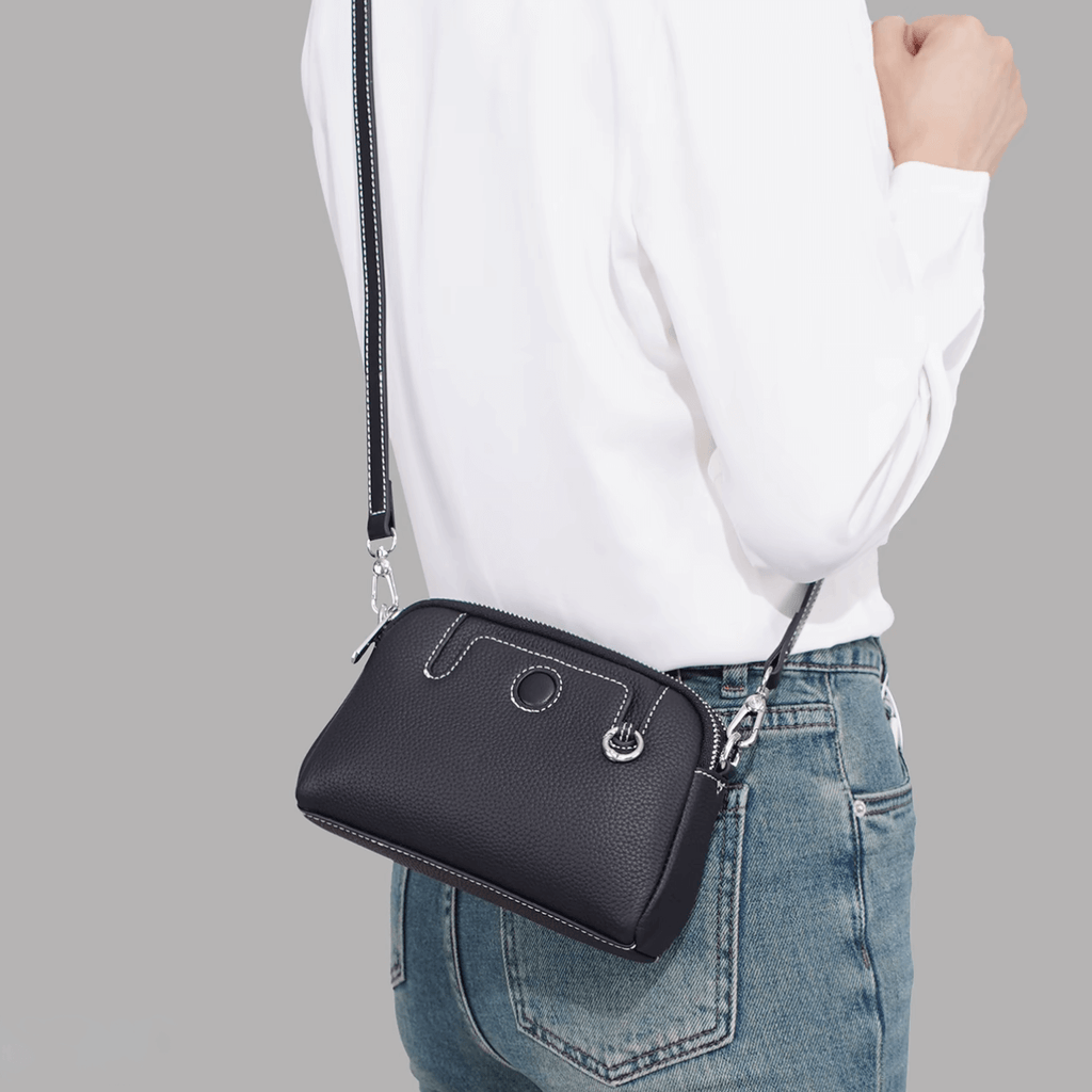 Mini leather crossbody bag worn crossbody by model showing strap length.