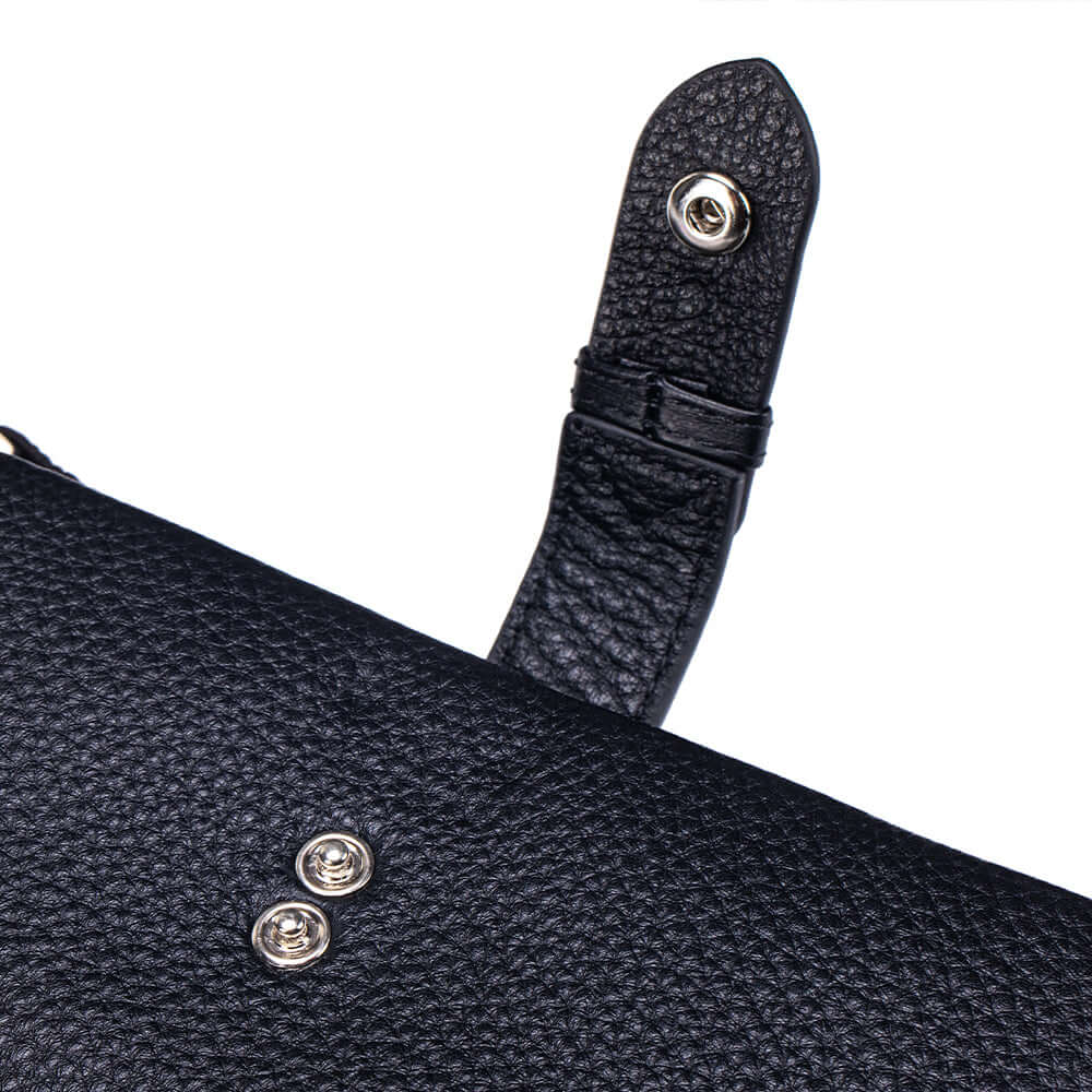 Close-up of a black textured handbag with a strap