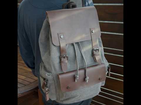 Grey vintage canvas backpack with leather accents, suitable for both casual and professional settings.