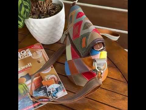 Vibrant leather crossbody bag displayed on a table