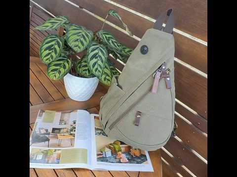 Green canvas sling bag with bottle side pocket and front zip