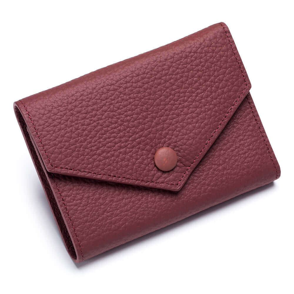 Red trifold leather wallet for women with secure button closure.