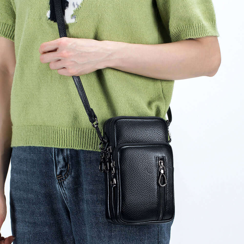 Small vertical leather crossbody phone bag for women, with ample capacity and adjustable strap.