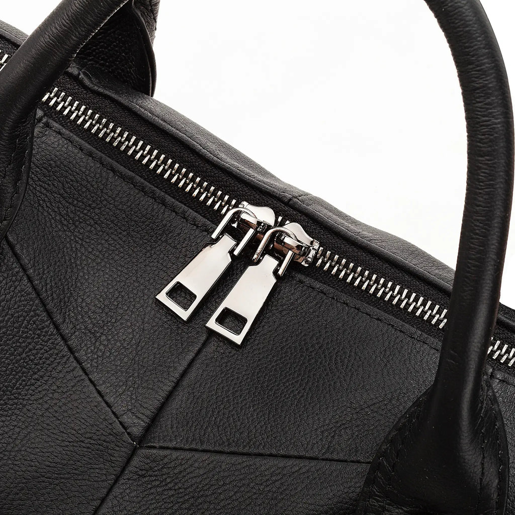 Close-up of black leather handbag with modern stitching detail