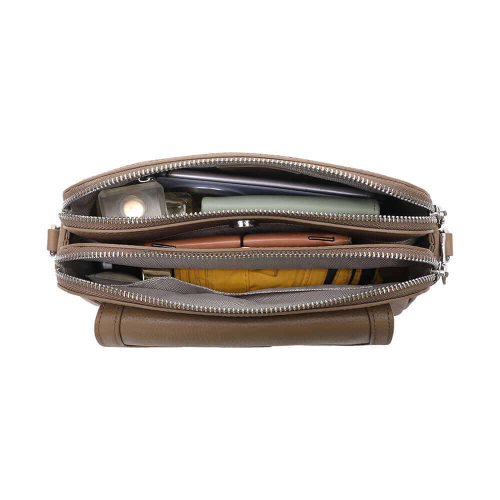 Taupe leather crossbody bag packed with daily essentials.
