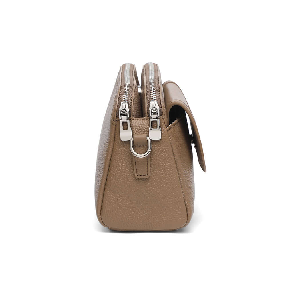 Side profile of taupe leather crossbody showing double zippers.