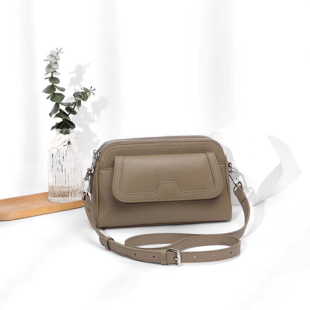 Taupe leather women’s crossbody with adjustable long strap.