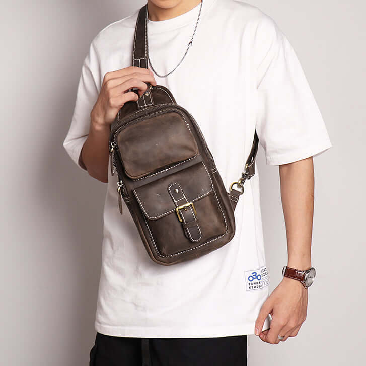 Model wearing vintage brown leather sling bag across the back – casual chest pack for men.
