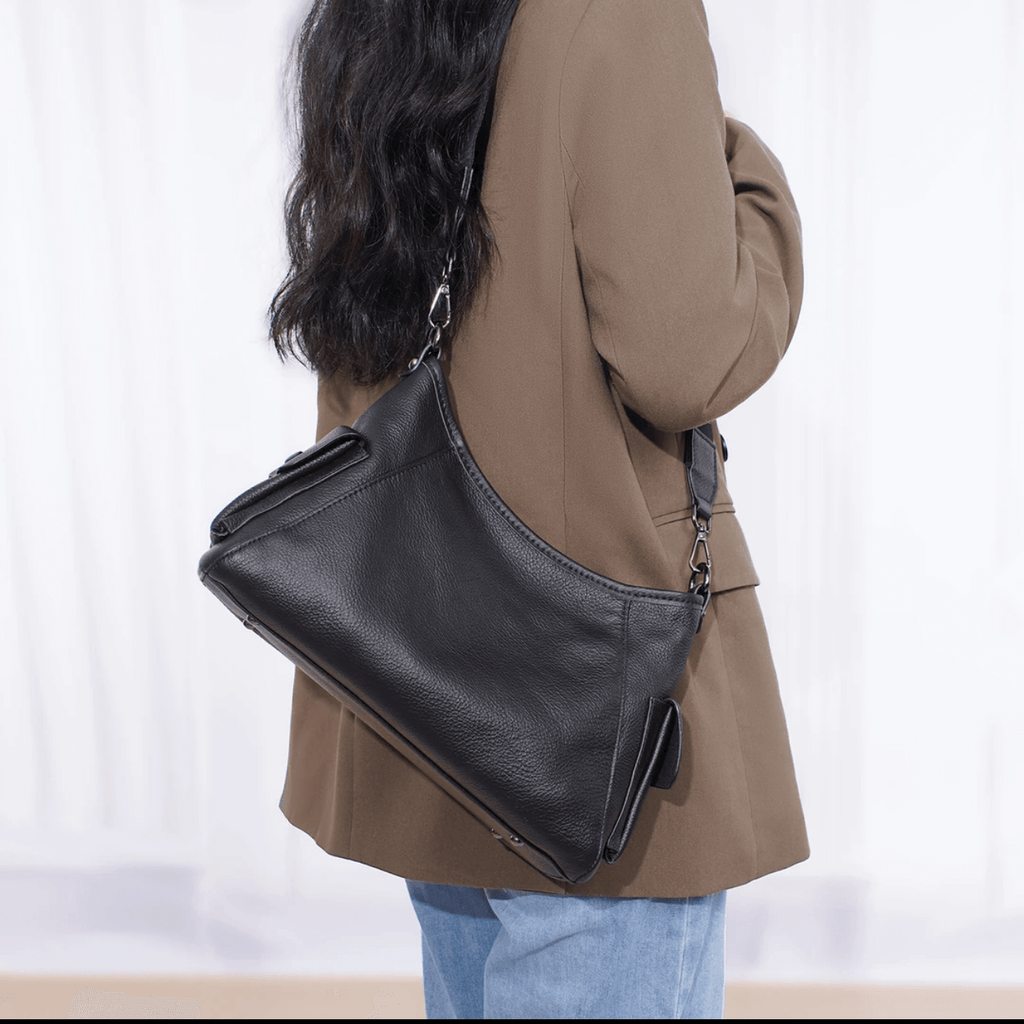 Model shows off black genuine leather handbag.