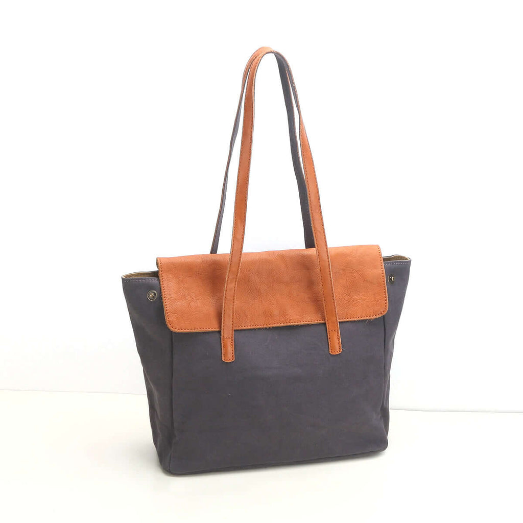 Grey canvas tote bag with leather flap front view.