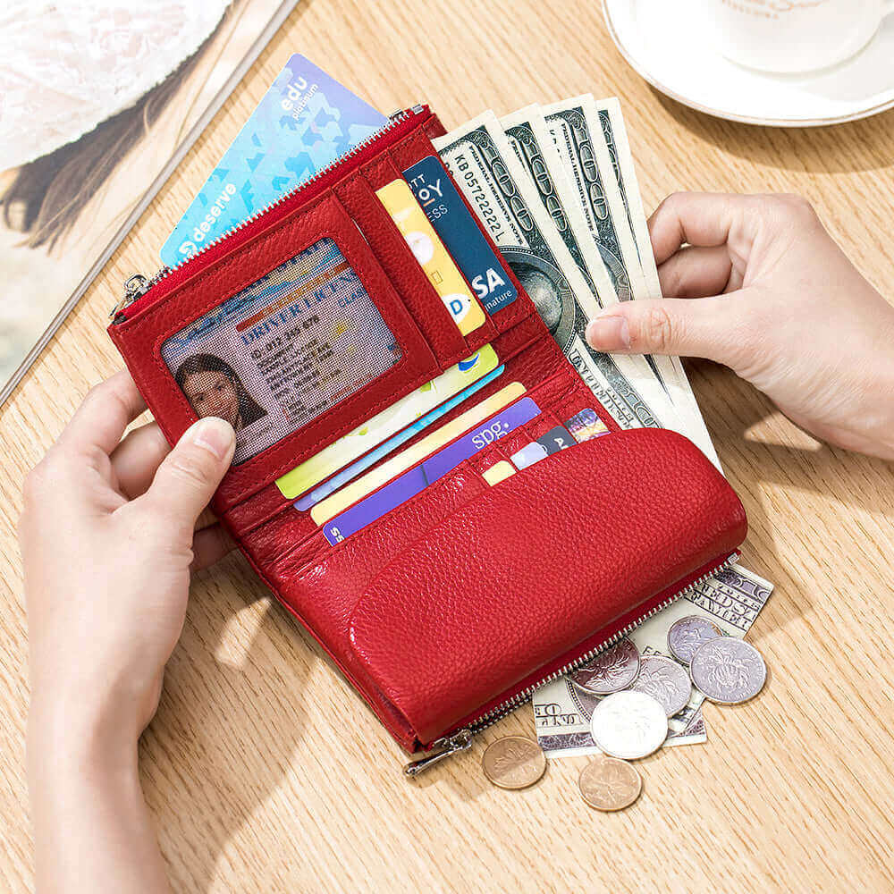 Women's red leather envelope wallet opened, showcasing organized compartments.