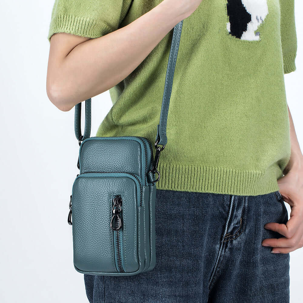 Women's leather crossbody bag with front and back zipper pockets, ideal for daily use.