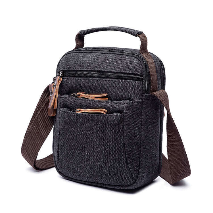 Black canvas crossbody bag with adjustable straps and secure zipper compartments.