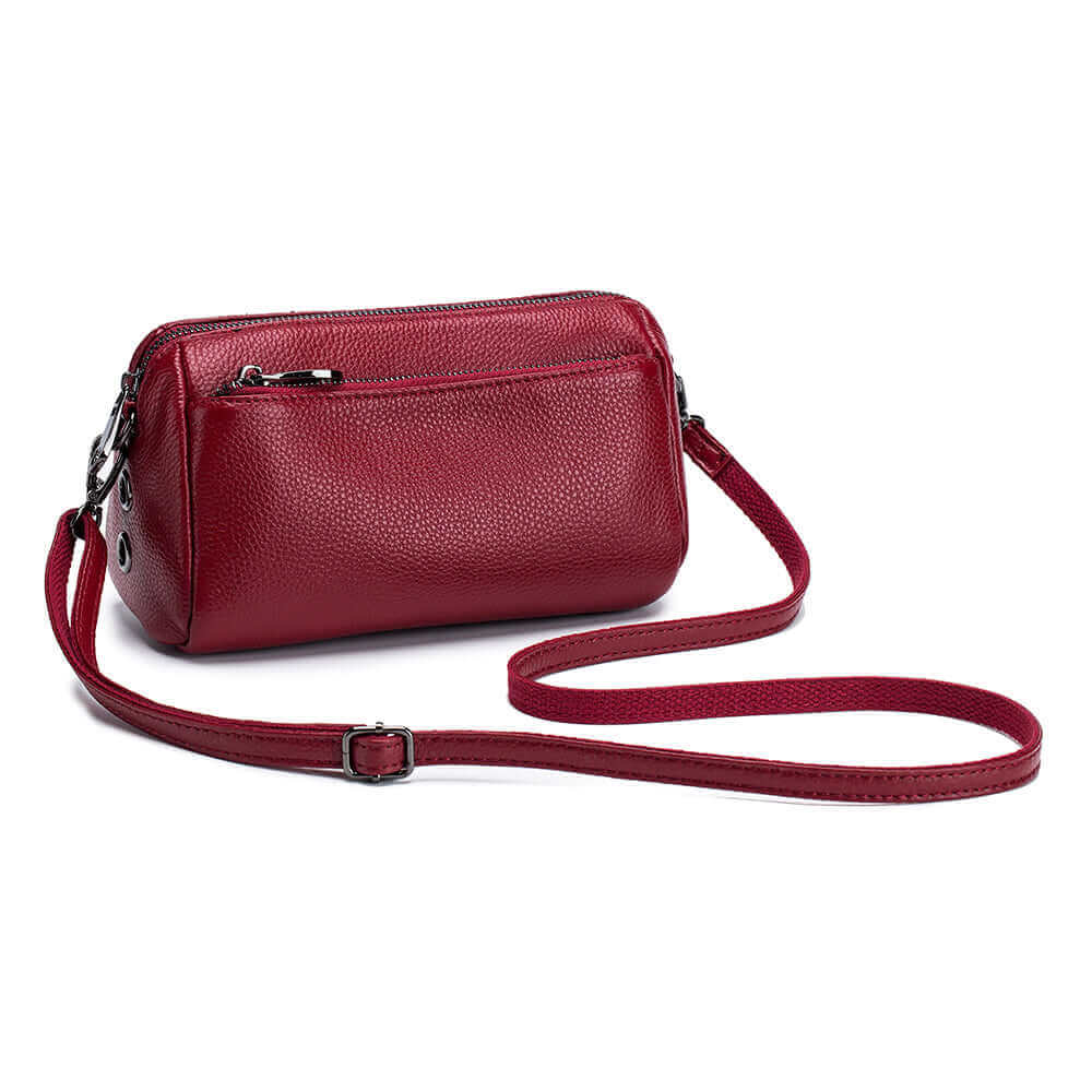 Compact leather shoulder bag with zipper closure and adjustable strap for versatile wear.