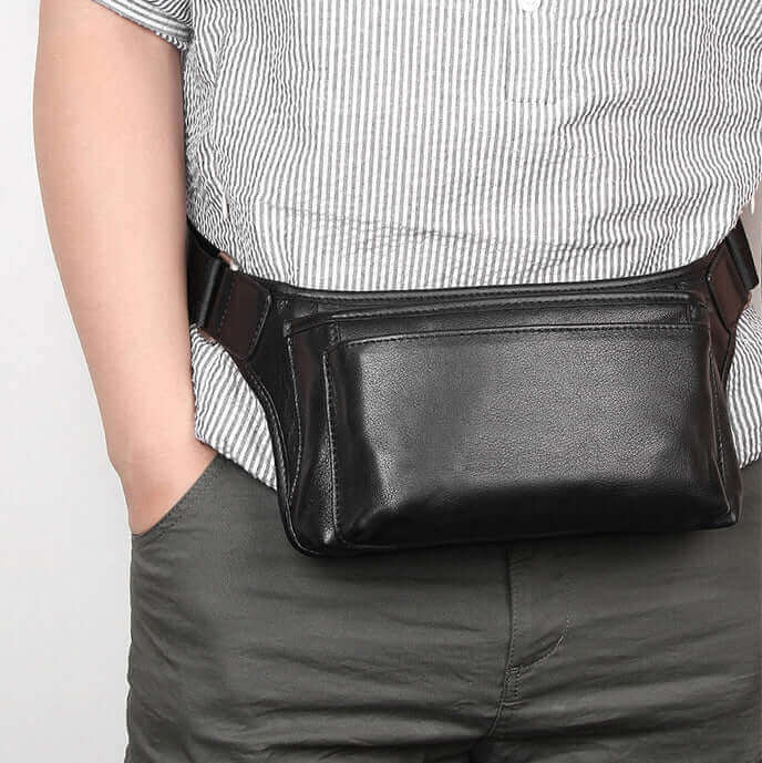 Black leather waist bag worn crossbody for versatile use.