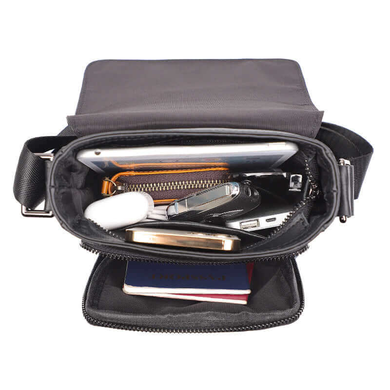 Open view of a small men's leather crossbody bag with a magnetic closure.