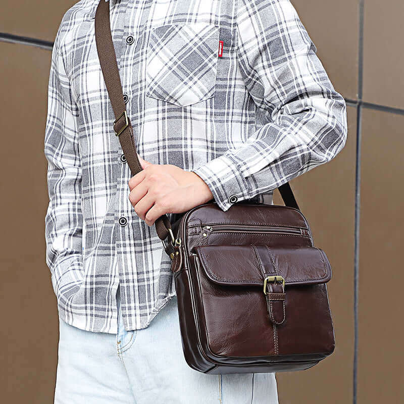 Stylish coffee brown leather crossbody bag with magnetic flap closure.